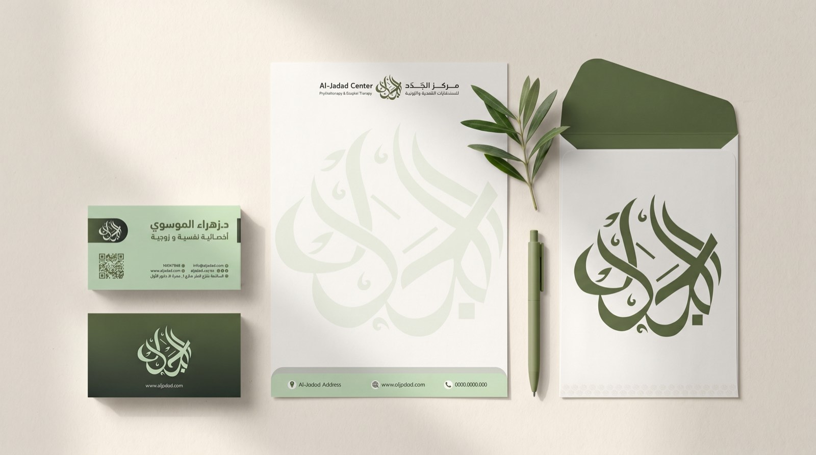Al-Jadad stationery suite — business cards, letterhead and envelope with the calligraphic logotype