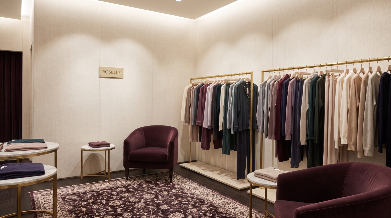 Roselle boutique interior with garment racks and plum armchairs